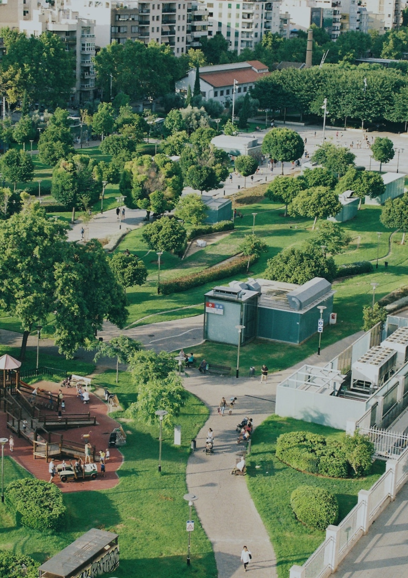 Stadtpark mit Wegen, Sitzgelegenheiten und Spielplatz aus der Vogelperspektive